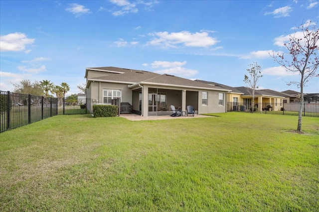 rear view of property featuring a yard, a patio, a fenced backyard, and stucco siding