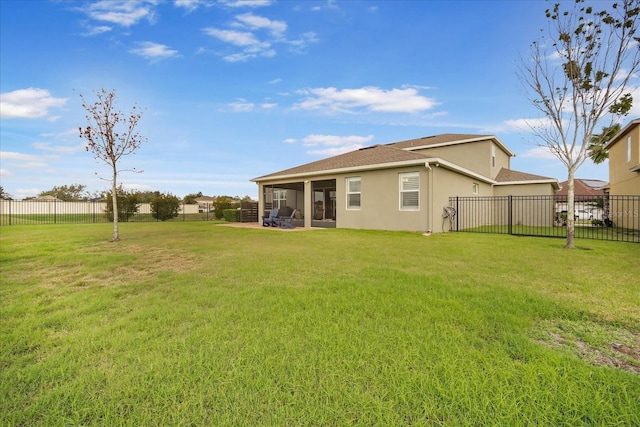 rear view of house featuring a fenced backyard and a yard