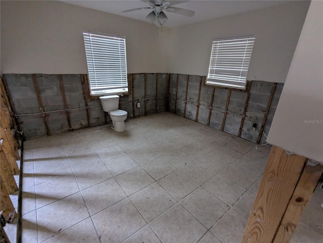 bathroom with a ceiling fan and toilet