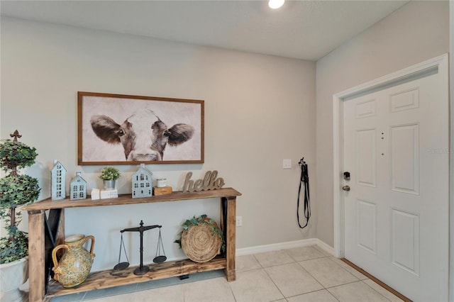 entryway with light tile patterned floors and baseboards