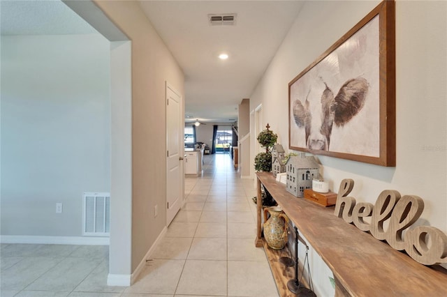 hall featuring light tile patterned floors, recessed lighting, visible vents, and baseboards