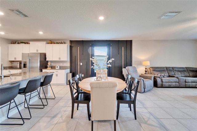 dining space with light tile patterned flooring, visible vents, and recessed lighting