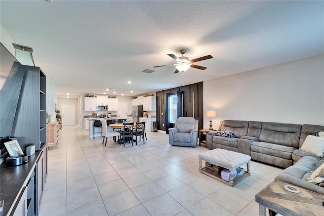 living area with light tile patterned floors, recessed lighting, visible vents, ceiling fan, and a textured ceiling