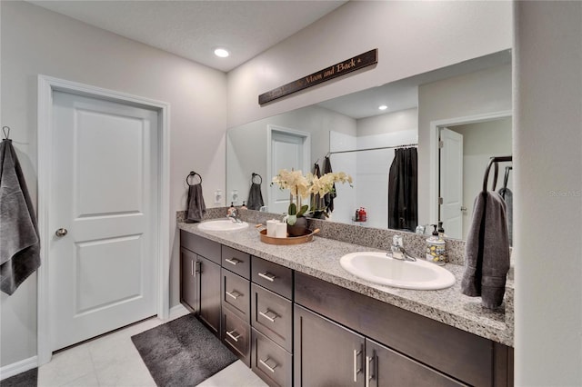 bathroom with double vanity, baseboards, a sink, and a shower with shower curtain