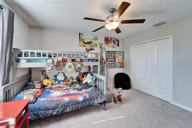 bedroom featuring a closet, visible vents, carpet flooring, ceiling fan, and baseboards