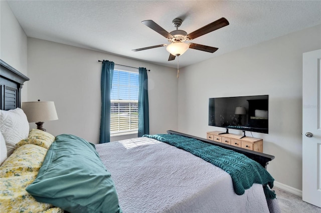 bedroom featuring ceiling fan, a textured ceiling, baseboards, and carpet flooring