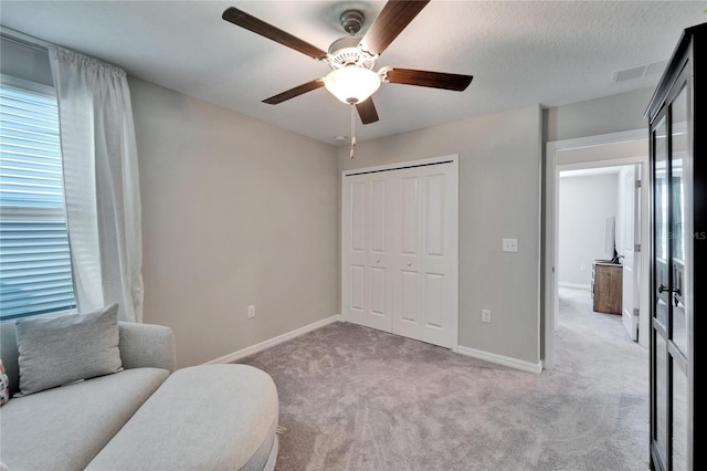 sitting room featuring light carpet, ceiling fan, baseboards, and a textured ceiling