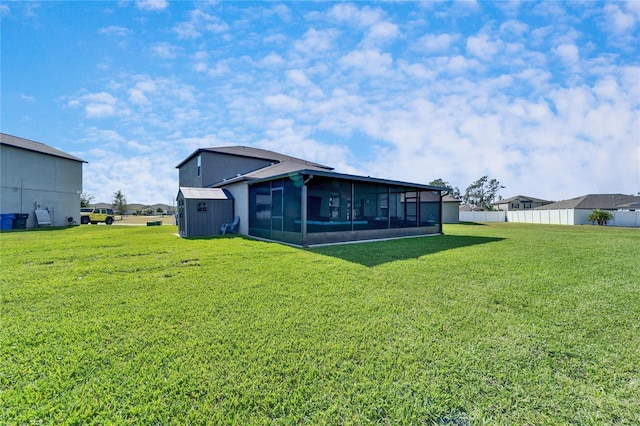 back of house featuring a sunroom, a lawn, and fence