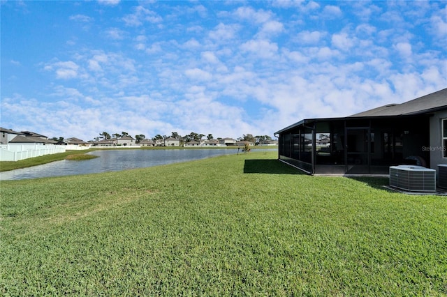 view of yard with a sunroom, a water view, and central air condition unit