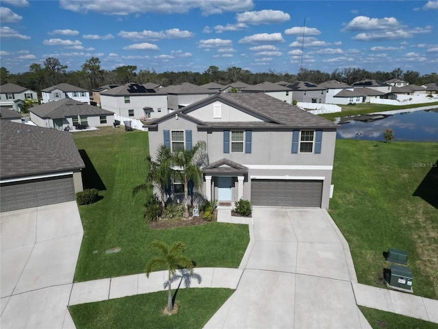 traditional-style home featuring a garage, driveway, a residential view, stucco siding, and a front lawn