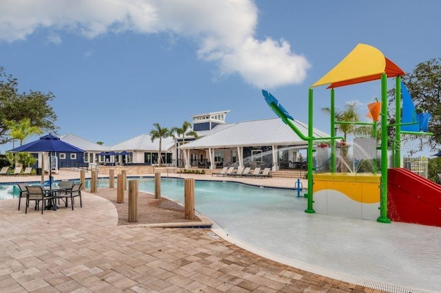 pool with a patio area and a water play area