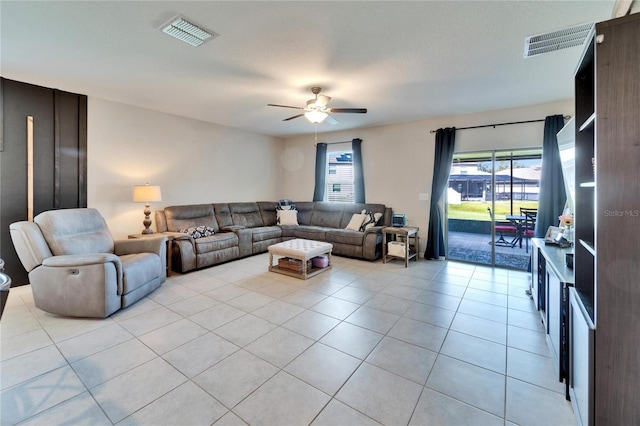 living room with light tile patterned floors, visible vents, plenty of natural light, and a ceiling fan