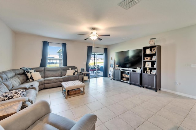 living room with light tile patterned flooring, visible vents, a healthy amount of sunlight, and a ceiling fan