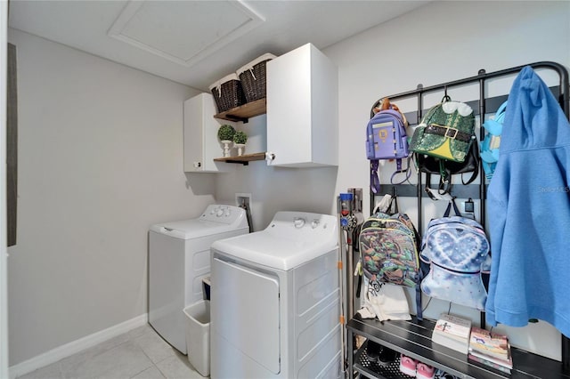 laundry area featuring light tile patterned floors, baseboards, attic access, cabinet space, and washer and dryer