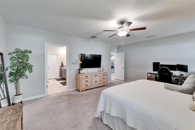 bedroom with ensuite bath, light colored carpet, visible vents, and baseboards