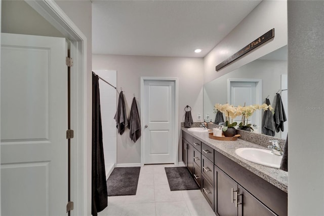 full bathroom with a sink, a shower with shower curtain, double vanity, and tile patterned flooring