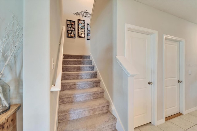 stairs with tile patterned floors and baseboards