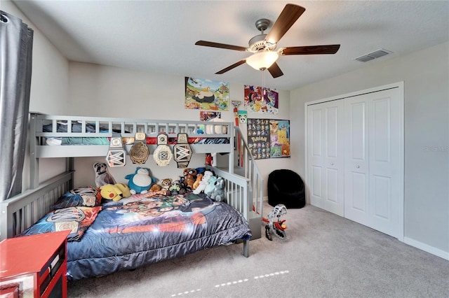 carpeted bedroom featuring a closet, visible vents, a ceiling fan, and baseboards