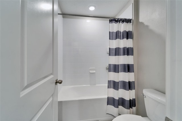 bathroom featuring shower / tub combo and toilet