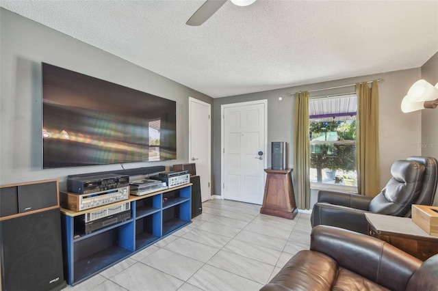 living area with ceiling fan and a textured ceiling