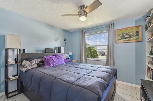 bedroom featuring a textured ceiling, light tile patterned flooring, a ceiling fan, and baseboards