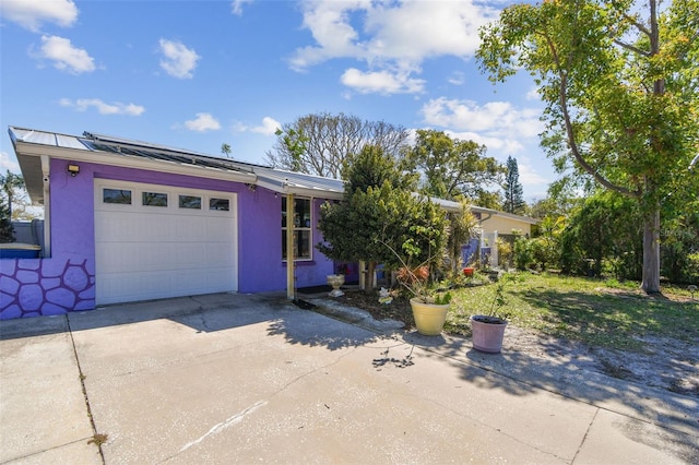 ranch-style house with driveway, a garage, and stucco siding