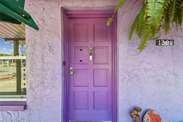 entrance to property with stucco siding