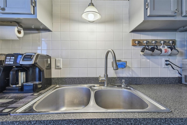 kitchen featuring dark countertops, a sink, and decorative backsplash