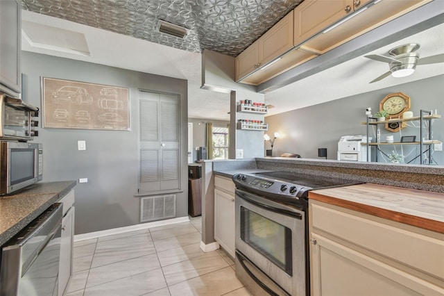 kitchen with stainless steel appliances, an ornate ceiling, visible vents, and wooden counters