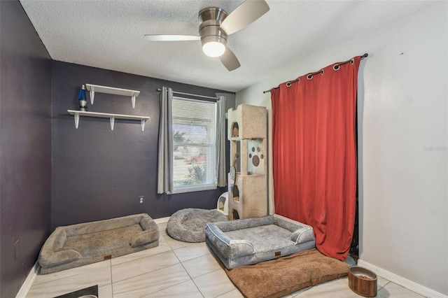 sitting room featuring ceiling fan, baseboards, and a textured ceiling