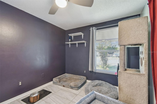 bedroom with tile patterned flooring, baseboards, ceiling fan, and a textured ceiling