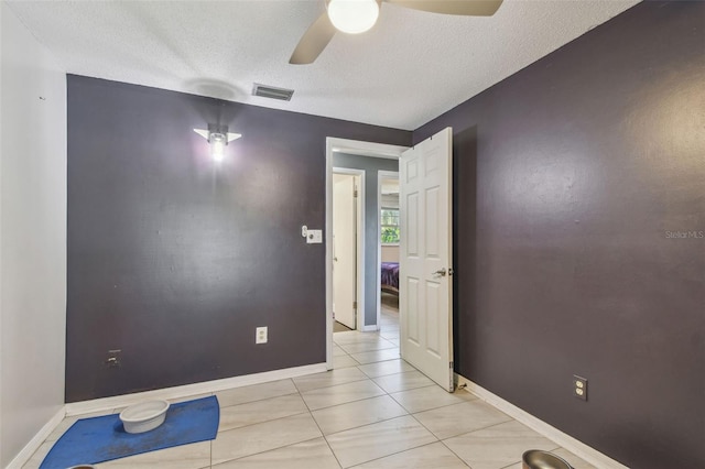 empty room featuring ceiling fan, visible vents, and baseboards