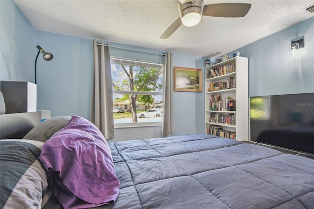 bedroom featuring a ceiling fan, visible vents, and a textured ceiling