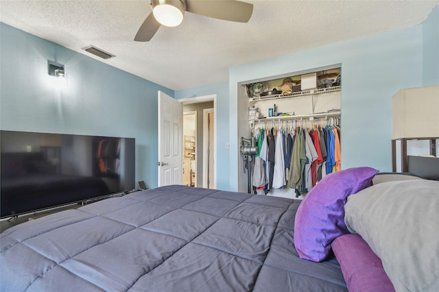 bedroom featuring a ceiling fan, a closet, visible vents, and a textured ceiling