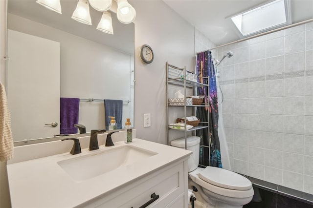 bathroom featuring tiled shower, vanity, and toilet