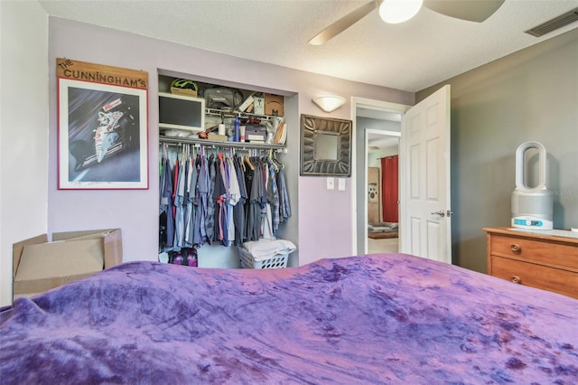 bedroom with a textured ceiling, a closet, visible vents, and a ceiling fan