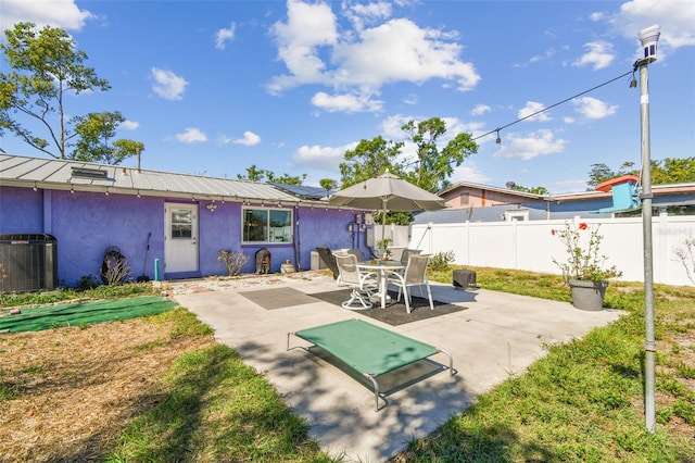 back of property featuring a patio, stucco siding, metal roof, cooling unit, and a fenced backyard