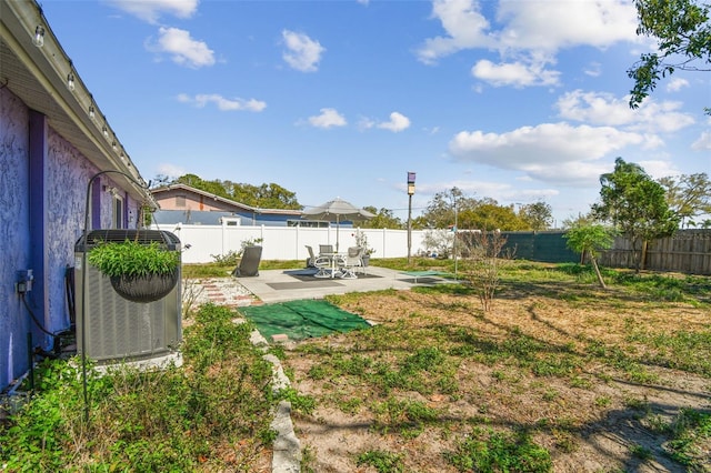 view of yard featuring a patio area, a fenced backyard, and central air condition unit