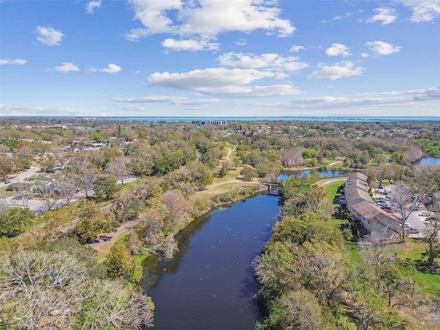 birds eye view of property featuring a water view and a view of trees