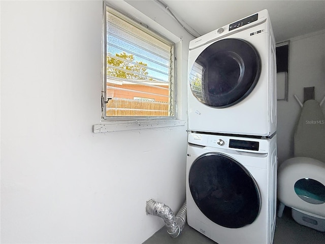 laundry room with stacked washer and clothes dryer and laundry area