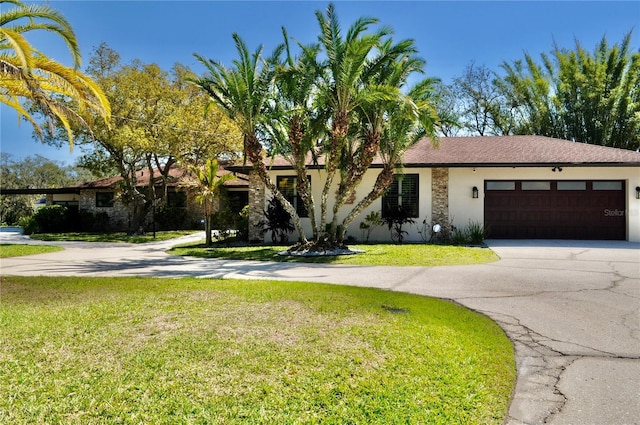 view of front of house with an attached garage, driveway, a front lawn, and stucco siding