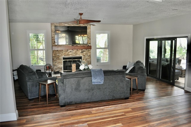 living room with a textured ceiling, a fireplace, and wood finished floors