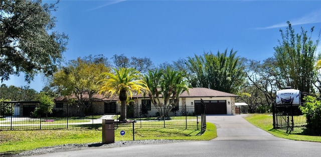 view of front of house featuring an attached garage, driveway, fence, and a front yard