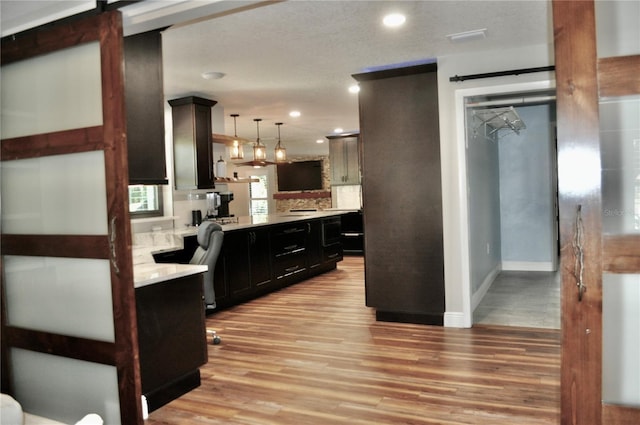 kitchen with light wood finished floors, light countertops, and a barn door