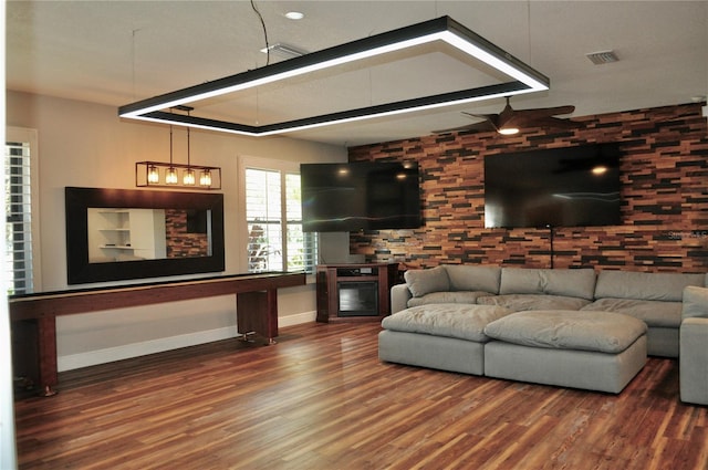 living room with baseboards, visible vents, wood finished floors, and a glass covered fireplace