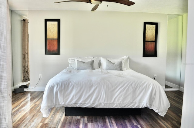 bedroom with wood finished floors, a ceiling fan, and baseboards