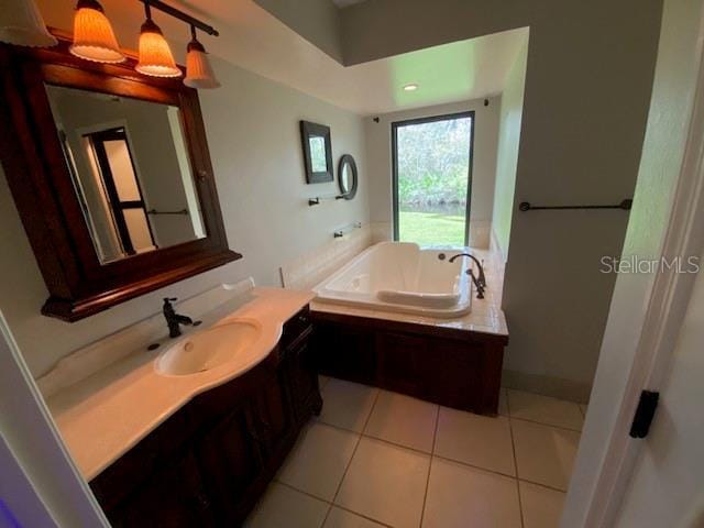 bathroom featuring a garden tub, vanity, and tile patterned floors