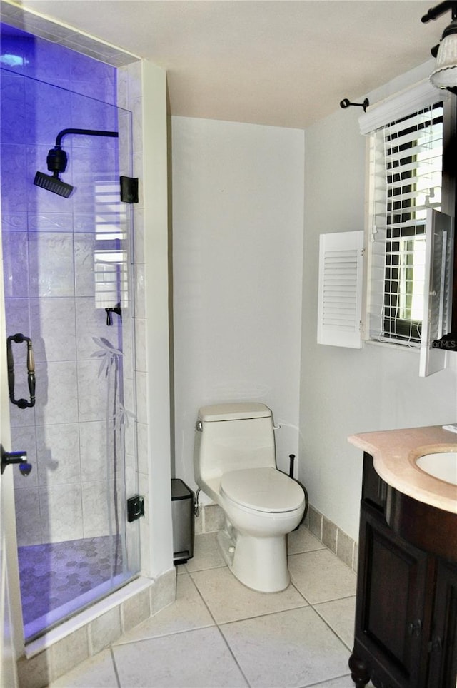 full bathroom featuring toilet, a shower stall, vanity, baseboards, and tile patterned floors