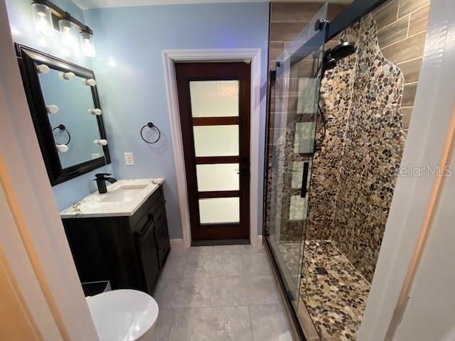 full bathroom featuring a stall shower and vanity