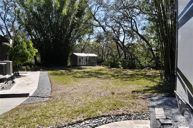 view of yard featuring a shed, central AC unit, and an outbuilding